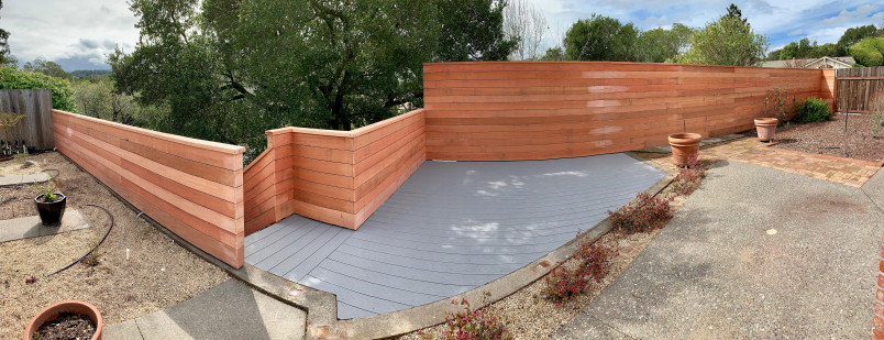 A residential deck with stairs leading downwards.